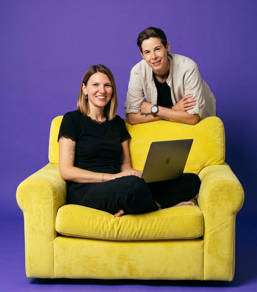 Franka und Kathi mit Laptop auf einem gelben Sessel